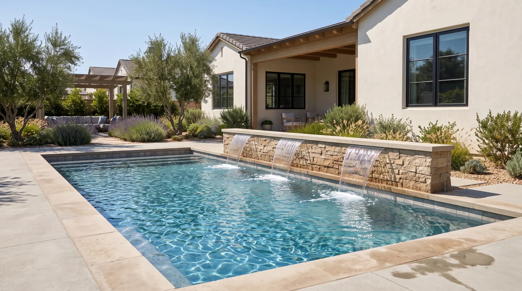 Modern backyard pool with three sheer-descent waterfalls spilling from a stone wall