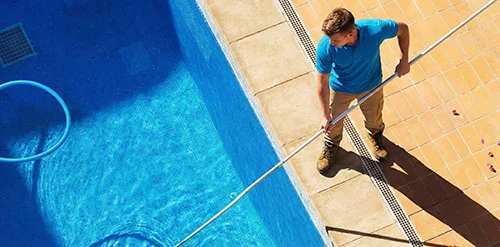 Pool technician vacuuming the pool